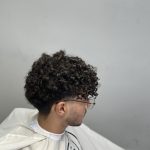 تصویر یک پسر است که موهایش را در سالن زیایی فر کرده است. آکادمی محمد فرشته